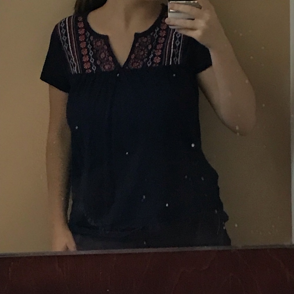 shirt with flowers embroidered in it.